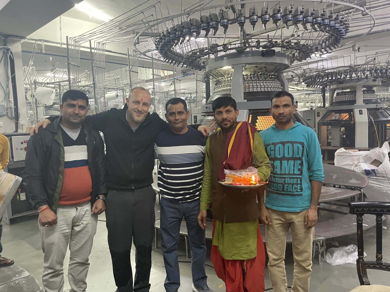 As a service technician, Caine-Allen travels to India to repair a machine. Afterwards, the customer is so grateful that he has the circular knitting machine and its technician blessed. © Mayer & Cie.